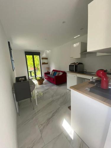 Il comprend une cuisine et un salon avec un canapé rouge. dans l'établissement Tiny House DALIA Jardin & forêt 10 min de la gare, à Dammarie-les-Lys