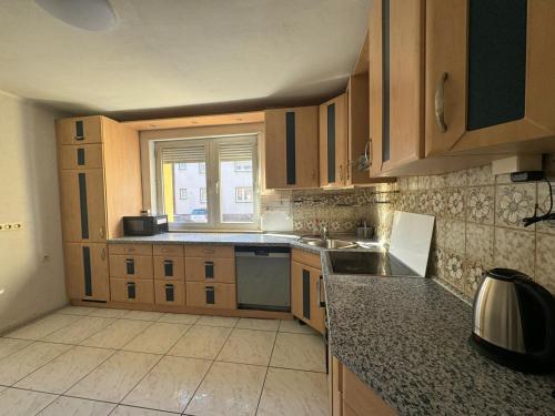 a kitchen with wooden cabinets and a sink and a window at 7 Zimmer Haus in Kaiserslautern in Kaiserslautern