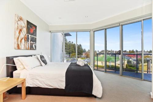 um quarto com uma cama e uma grande janela em Gallery Resort Style Penthouse No 13 em Victor Harbor