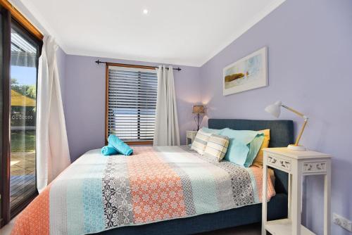 a bedroom with a bed and a window at Goolwa Blue Escape - Beach Spacious Wi-fi in Goolwa