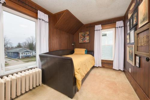 um quarto com uma cama e uma grande janela em Clinton Street Retreat -Dog Friendly- Close to downtown em South Haven