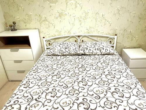 a bedroom with a bed with a black and white comforter at Автовокзал in Rivne