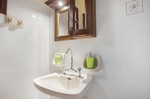 uma casa de banho branca com um lavatório e um espelho em Castellos Bellos Studio 1 em Marathias