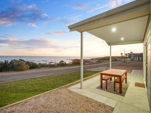 a porch with a table and a view of the ocean at High Tide Shack on Palmer - Pet Friendly in Wallaroo