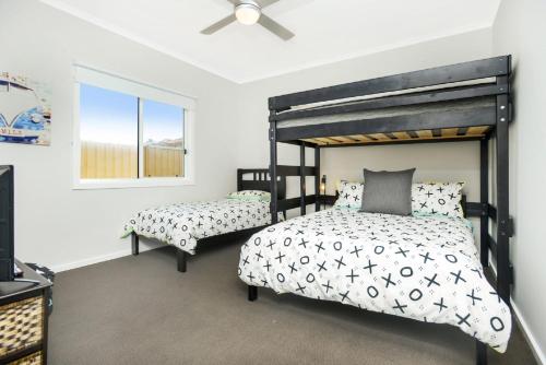 ein Schlafzimmer mit einem schwarzen Bett und einem Fenster in der Unterkunft High Tide - Beachfront Pet-friendly in Wallaroo