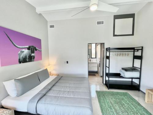 - une chambre avec un lit et une vache sur le mur dans l'établissement Onyx Oasis: Pool, Fire Pit, Great Views, Sleeps 6, à Canyon Lake