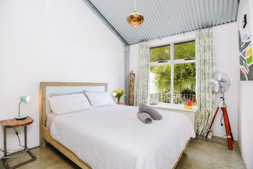 1 dormitorio con cama blanca y ventana en Pelican Cottage - Pet Friendly - Wifi, en Goolwa North