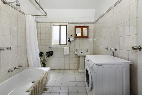 a white bathroom with a washing machine in it at Riverglades Murray Bridge in Murray Bridge