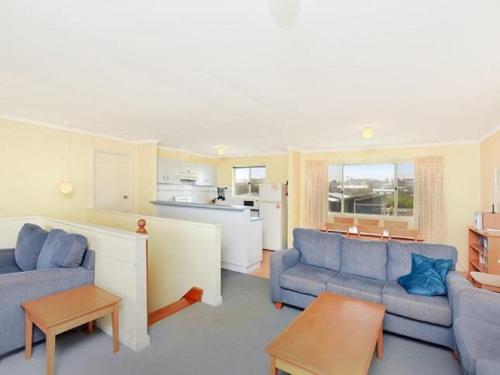 a living room with two blue couches and a kitchen at Tahren Beachfront Shack Wifi - Pet-friendly in Middleton