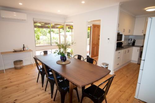 a kitchen and dining room with a wooden table and chairs at Sandy Pool Shack - Pet Friendly in Seacliff