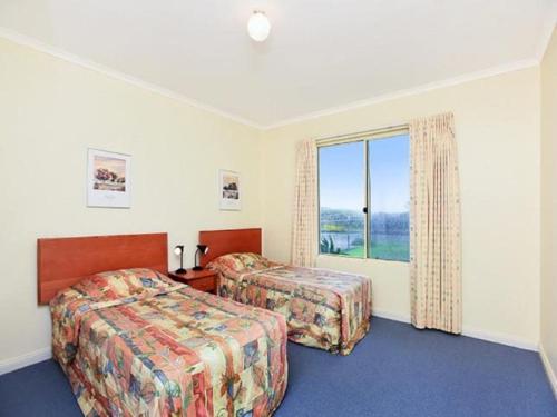 ein Hotelzimmer mit 2 Betten und einem Fenster in der Unterkunft Tahren Beachfront Shack Wifi - Pet-friendly in Middleton