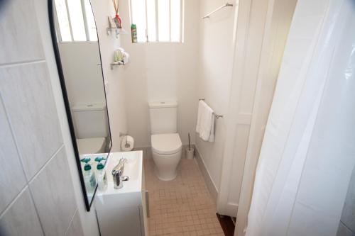 a small bathroom with a toilet and a sink at Sandy Pool Shack - Pet Friendly in Seacliff