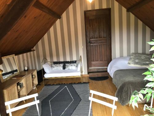 a room with two beds and a bench in a attic at Chambre vue sur la vallée in Crouttes