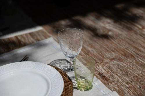 a wooden table with a plate and a wine glass at Château La Gravière in Vertheuil-en-Médoc