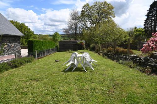 Caurel的住宿－Caurel Cottage，两把白色椅子坐在院子里的草地上