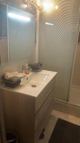 La salle de bains est pourvue d'un lavabo blanc et d'un miroir. dans l'établissement Laila, à Creil