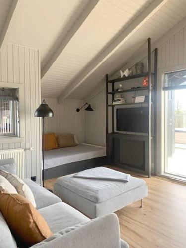 a living room with a couch and a tv at Heart of the Golden Circle with Hot Tub in Selfoss