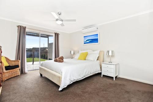 een slaapkamer met een bed met een teddybeer erop bij Sa Holiday House 'dunes Views On Simpson' in Goolwa