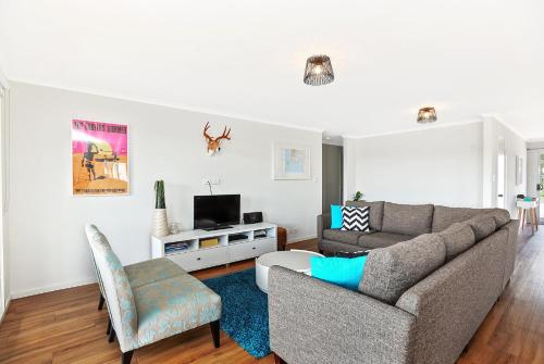a living room with a couch and a tv at Sa Holiday House 'dunes Views On Simpson' in Goolwa