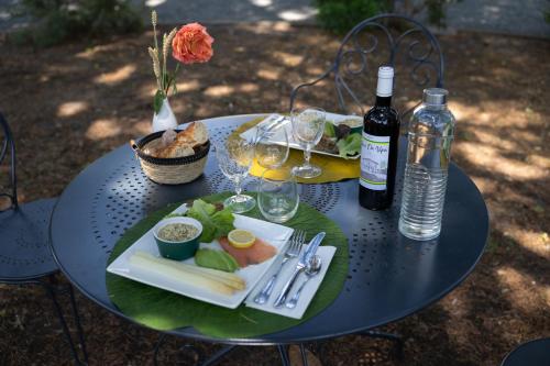 a table with a plate of food and a bottle of wine at Château La Gravière in Vertheuil-en-Médoc