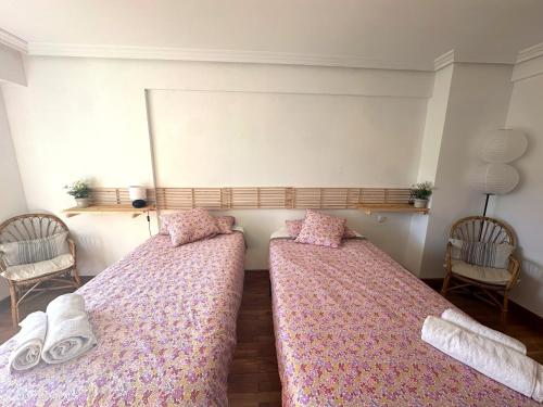 two beds in a room with two chairs at Habitaciones Hondar-Gain 10 in Zumaia