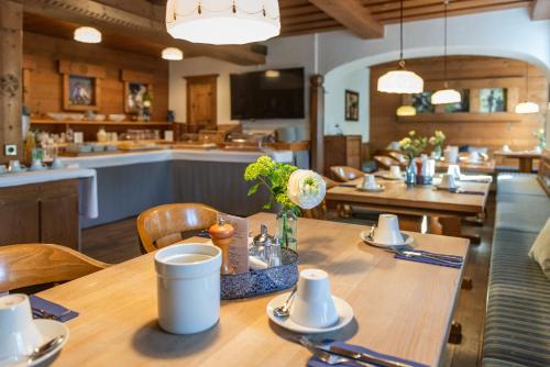 a dining room with a table and a kitchen at Hotel Terofal in Schliersee