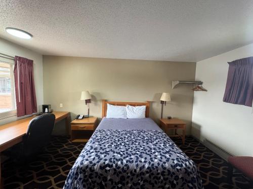 Habitación de hotel con cama y escritorio en Euclid Motel, en Bay City