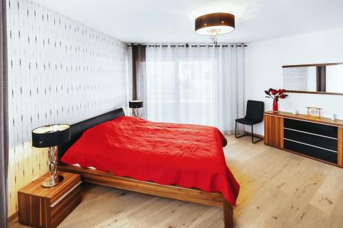 um quarto com uma cama vermelha e uma secretária em Montreux Lake View Apartment 4 Bedrooms em Montreux