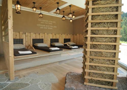 a room with three beds in a room with a ladder at Hotel Chalet Dlaces in Selva di Val Gardena