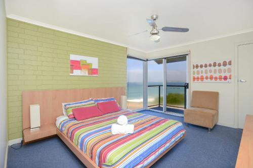 a bedroom with a large bed and a chair at South Seas - Port Elliot Beachfront Apt - Wifi in Port Elliot