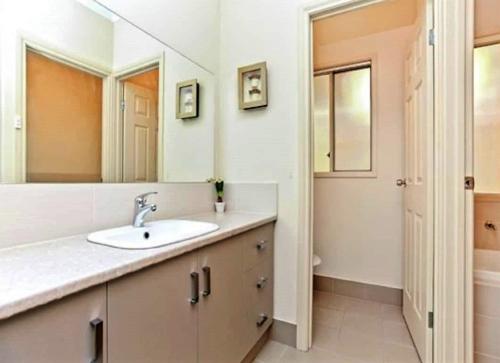y baño con lavabo y espejo. en Waterfront Retreat With Wifi, en Hindmarsh Island