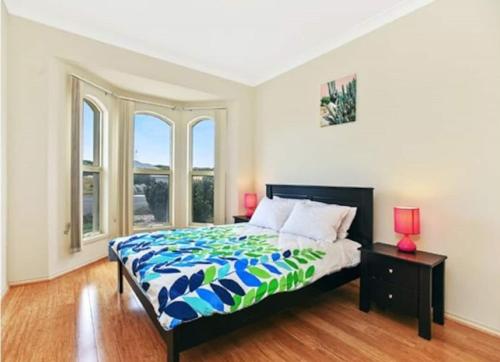 1 dormitorio con 1 cama y 2 ventanas en Waterfront Retreat With Wifi, en Hindmarsh Island