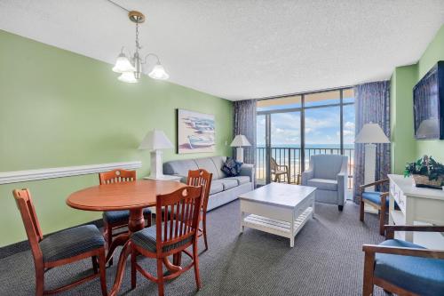 a living room with a couch and a table and chairs at Sand Dunes Resort and Suites in Myrtle Beach