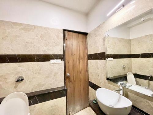 een badkamer met een wastafel, een toilet en een spiegel bij Hotel Rudraksh ! Varanasi ! fully-Air-Conditioned hotel at prime location with Parking availability, near Kashi Vishwanath Temple, and Ganga ghat 3 in Varanasi