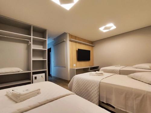 um quarto de hotel com duas camas e uma televisão em Hotel Pepita Palace em Sinop