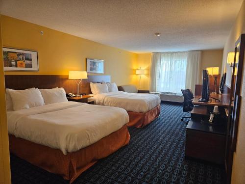 a hotel room with two beds and a television at Comfort Inn & Suites Ankeny - Des Moines in Ankeny