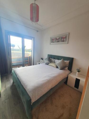 a bedroom with a large bed and a window at HEAVEN BEACH in Sidi Rahal
