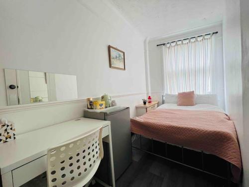 a bedroom with a bed and a desk with a mirror at St Pancras Private Rooms in London