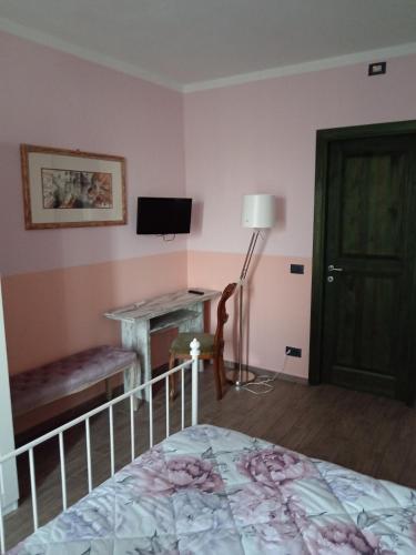 a bedroom with a bed and a desk and a television at Ospitidelpero in Piozzo