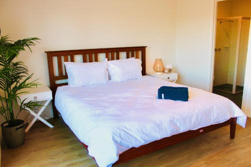 a bedroom with a bed with a blue bag on it at Vista Victor Harbor Beachfront Apartment No 4 in Victor Harbor