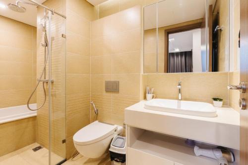 ein Bad mit einem WC, einem Waschbecken und einer Dusche in der Unterkunft Lynn Housing- Vinhomes Metropolis- LUX. Apartment system in Hanoi