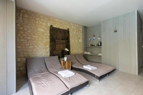 two twin beds in a room with a wall at Château La Gravière in Vertheuil-en-Médoc