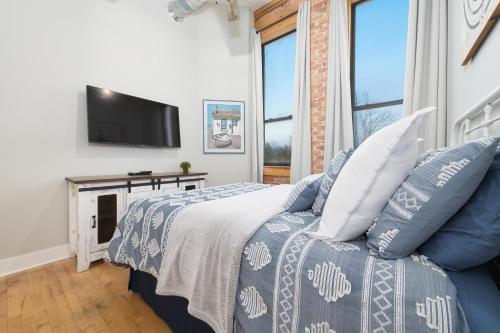 a bedroom with a bed and a flat screen tv at Central Lofts condo- year round pool- hot tub- close to beach in South Haven