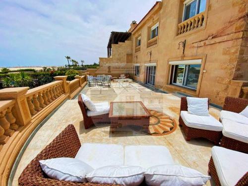 um pátio com cadeiras, uma mesa e um edifício em Villa with a charming view, sea view, Marina em El Alamein