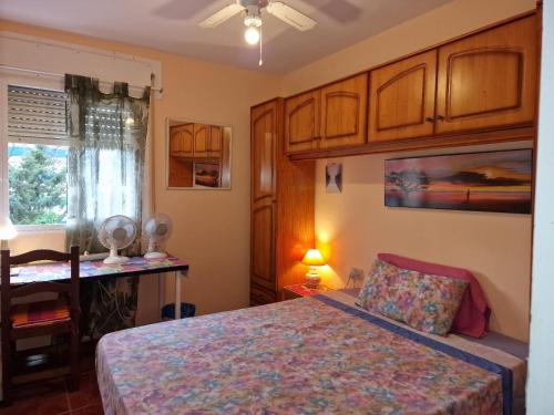 1 dormitorio con cama, escritorio y ventana en Fuengirola Rooms Boliches Beach, en Fuengirola