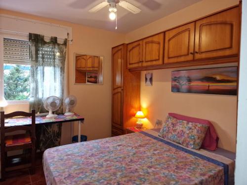 una camera con letto, scrivania e finestra di Fuengirola Rooms Boliches Beach a Fuengirola