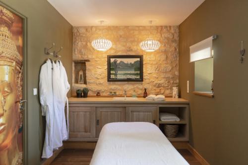 a bathroom with a bed and a sink at Château La Gravière in Vertheuil-en-Médoc