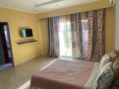 a bedroom with a bed and a tv and a window at JUCENTE_ALOJAMENTO_LOCAL in Quifica