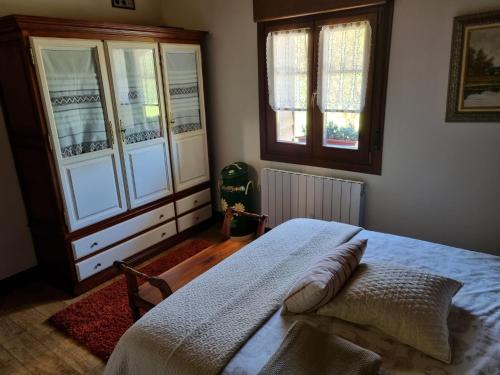 a bedroom with a bed and two windows at Gaztañeta Baserria in Olaeta
