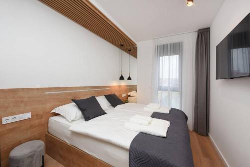 a bedroom with a large bed with a tv on the wall at FUX Penthouse Whirlpool Meerblick Zadar in Zadar